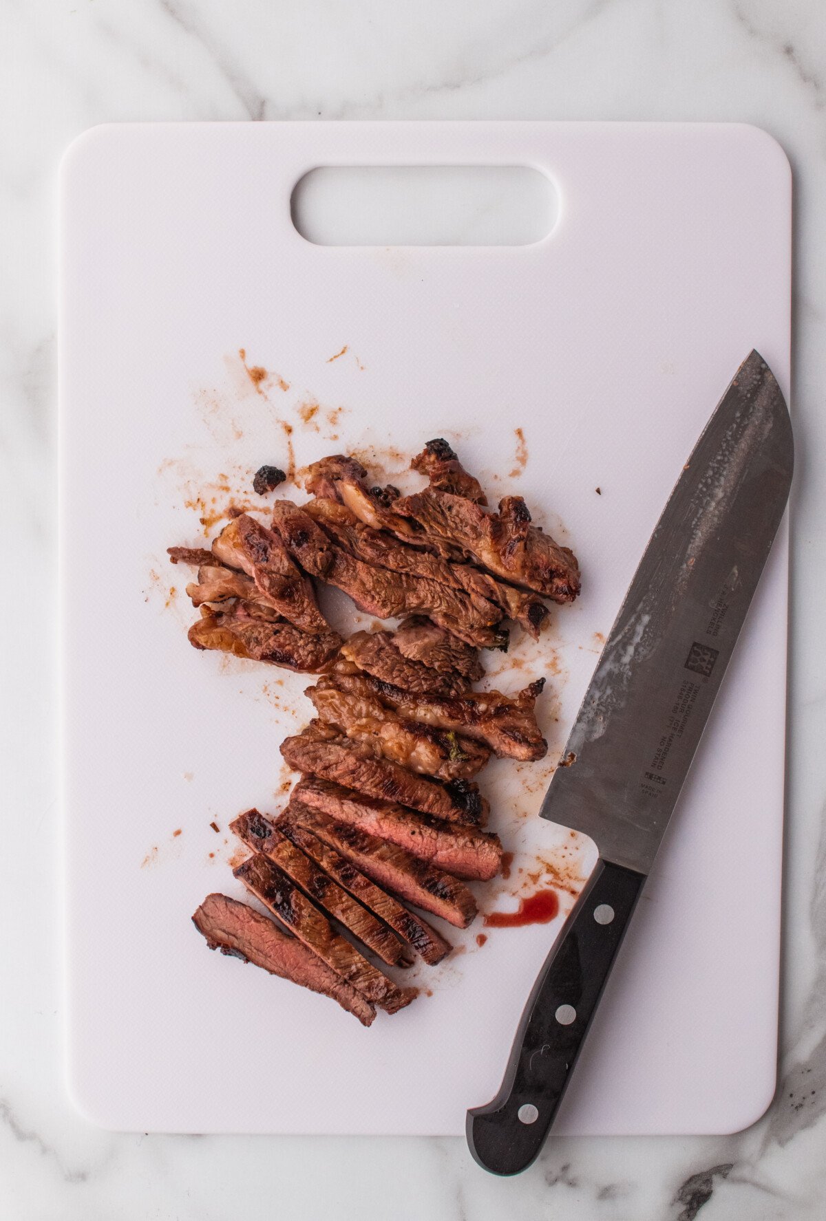 cutting board of steak meat getting sliced