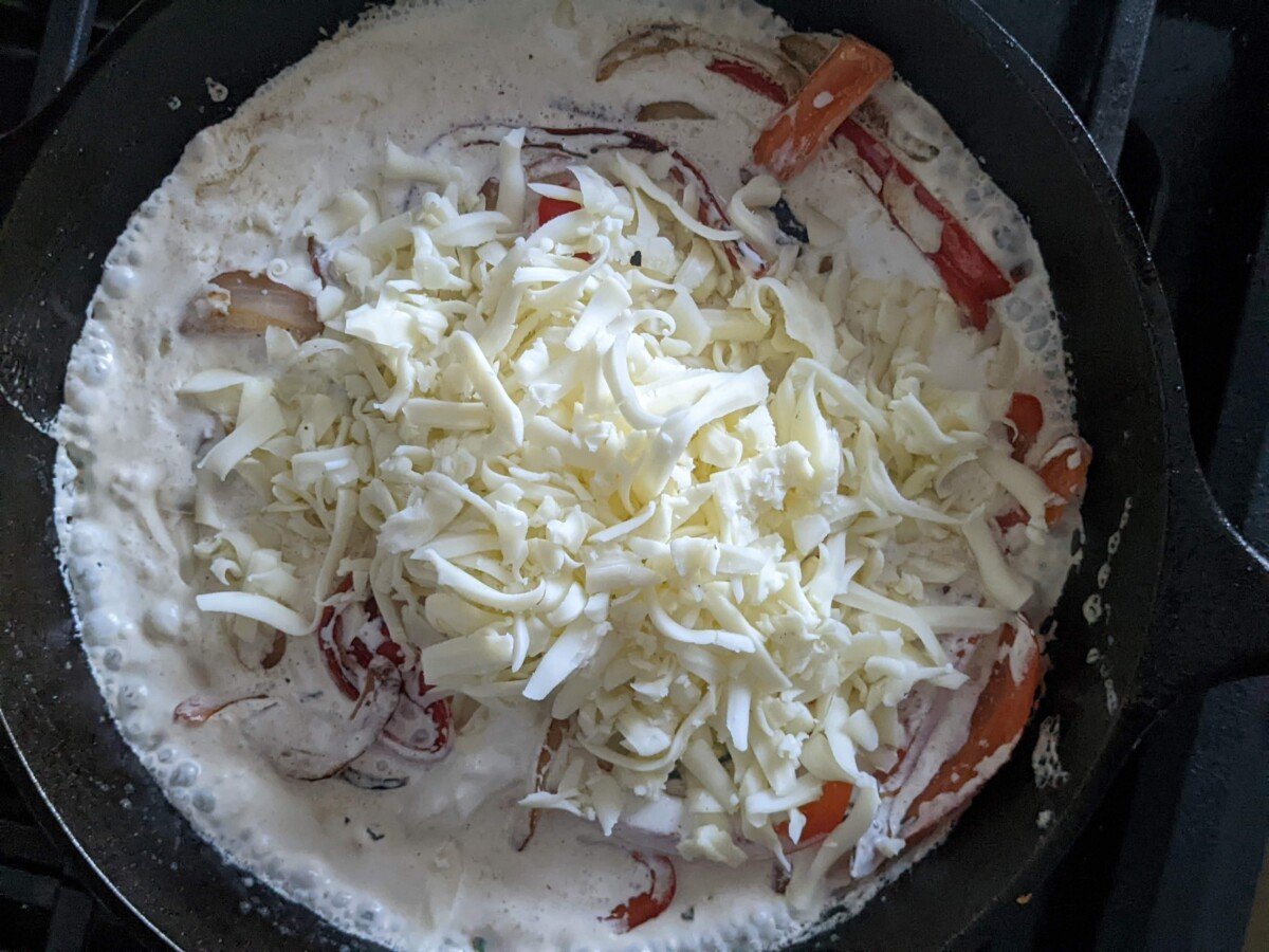 Cheese being added to the skillet.