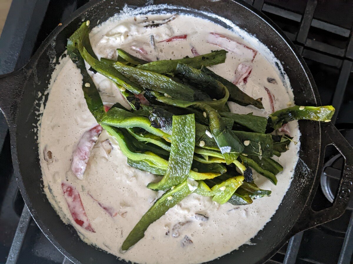 Sliced poblanos added to the skillet. 