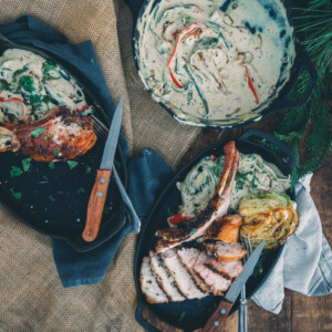 Two pans of rajas con crema on a table with a knife and fork.