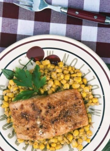 Flat lay photo of Baked Maple Salmon with sweet corn served on a dinner plate.