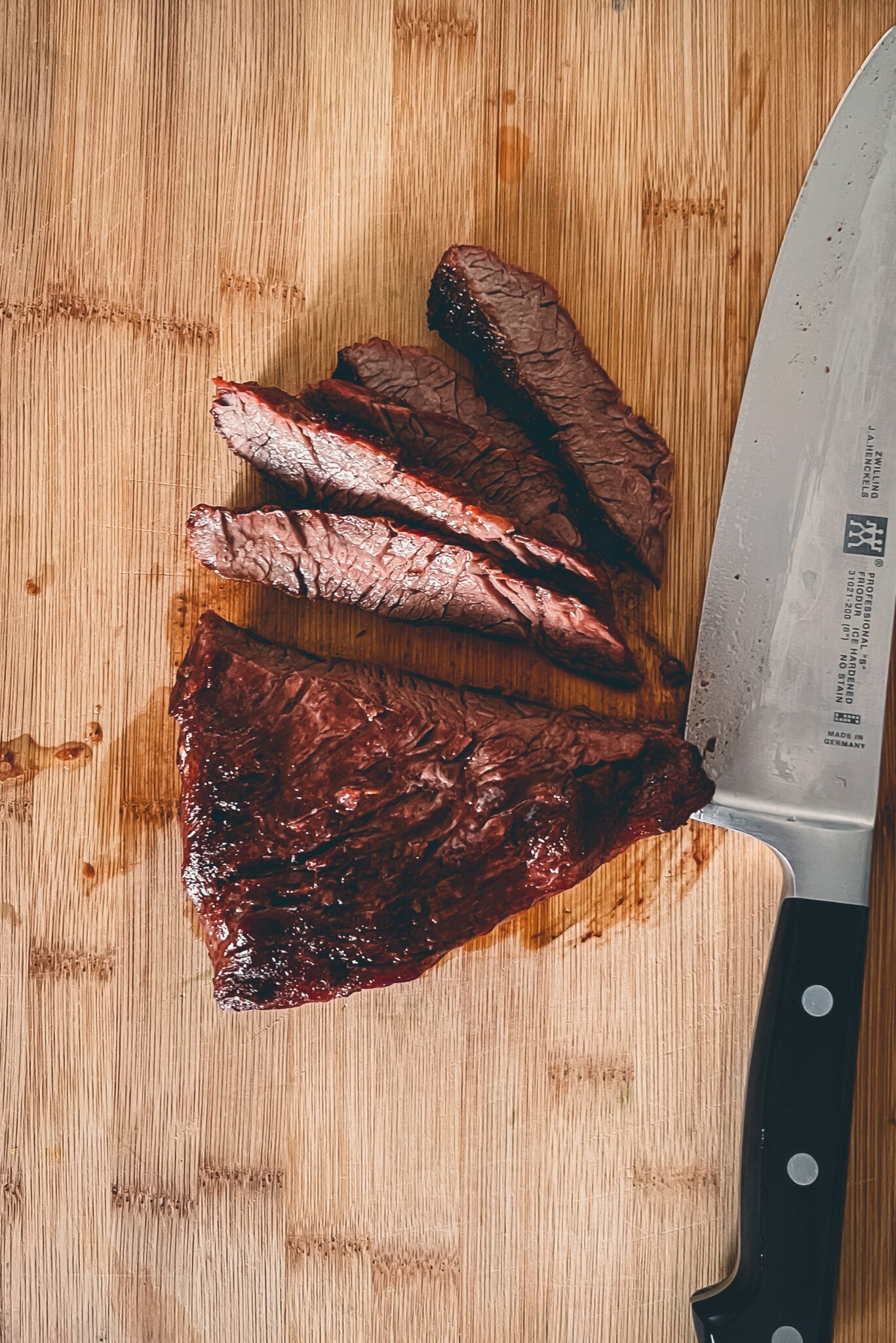 Showing a bavette steak being sliced against the grain to improve texture. 