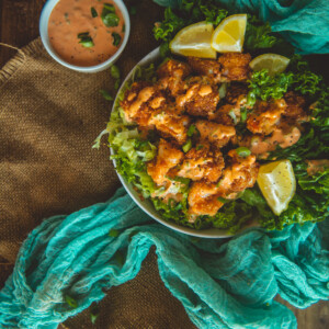 Above shot of white bowl filled with crispy panko coated shrimp and bang bang sauce.