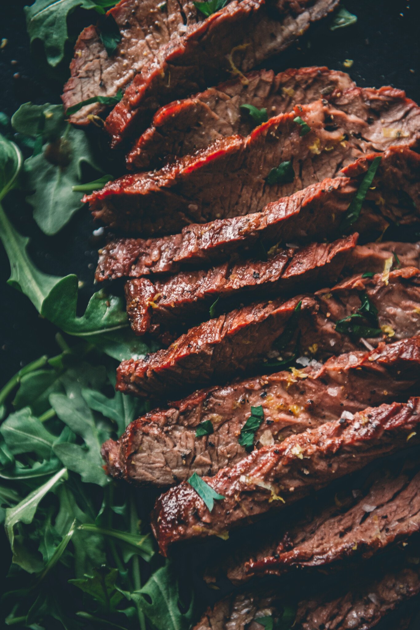 close up of sliced bavette steak to show the grain in juicy slices over. 