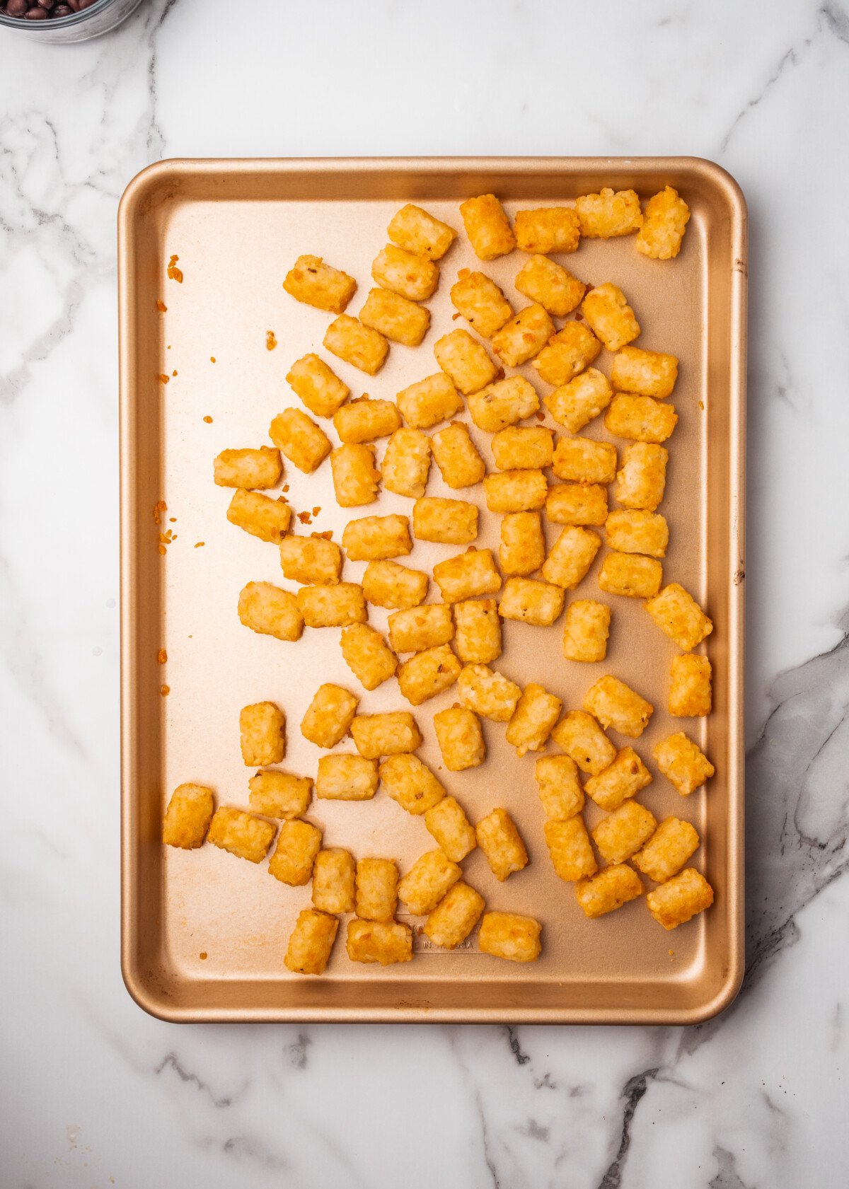tater tots laid out on a baking sheet