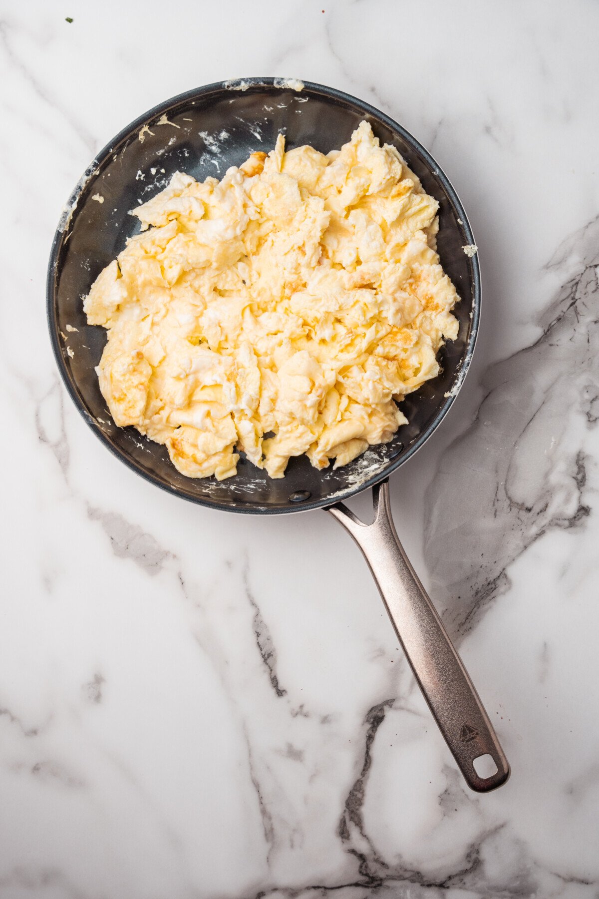 overhead shot of cooked scrambled eggs in a pan