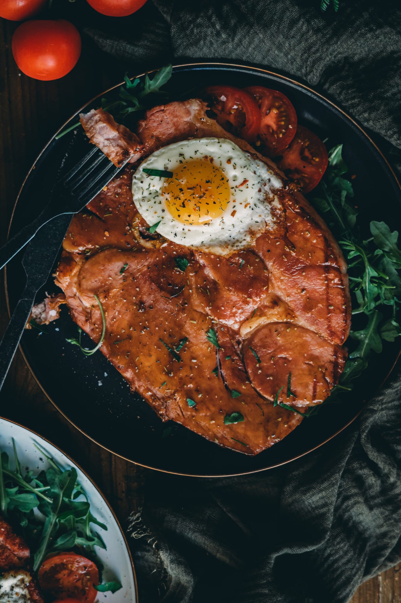 Overhead image of a glazed ham steak and fried egg.
