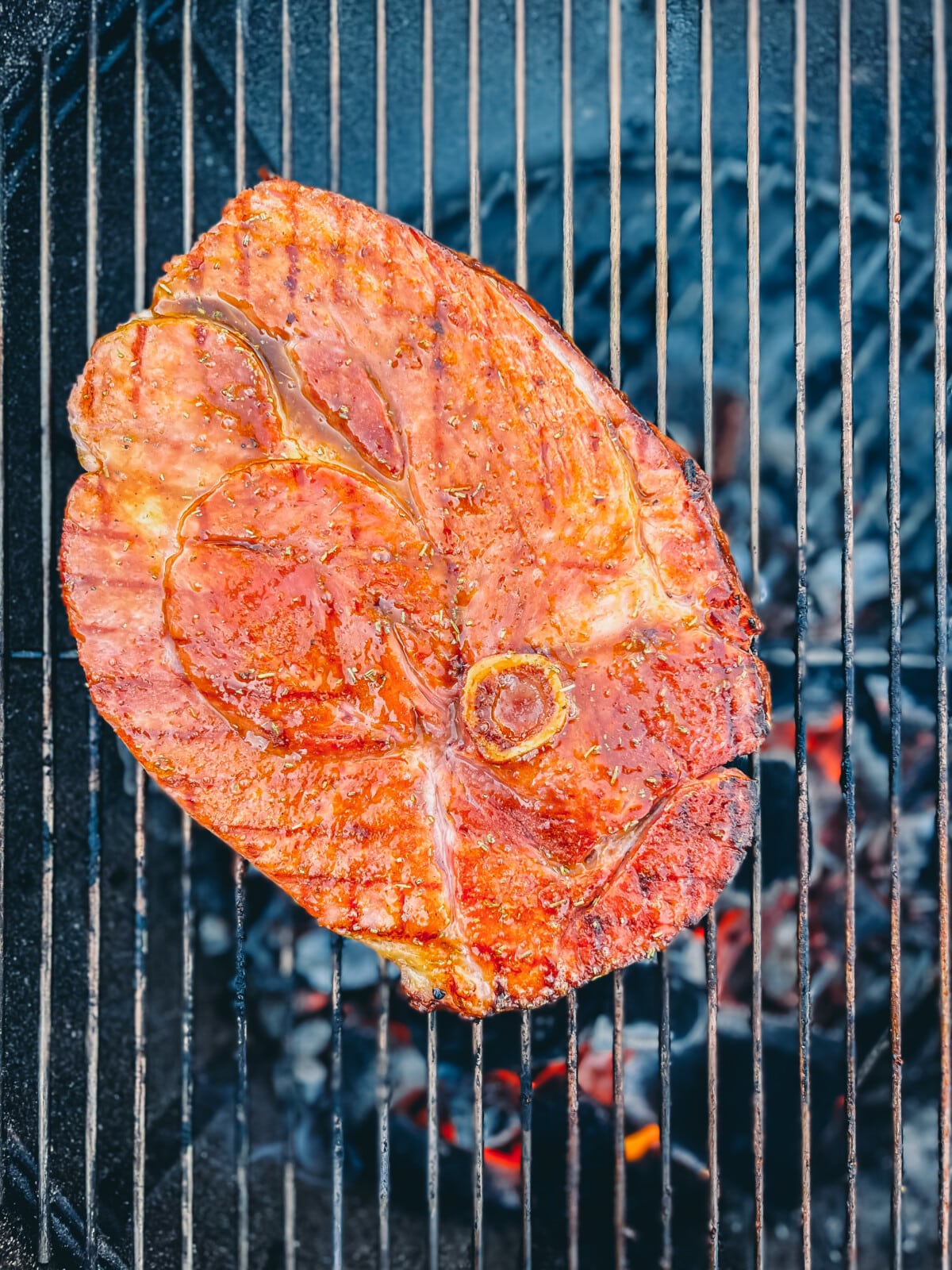 glazed ham steak on a grill.
