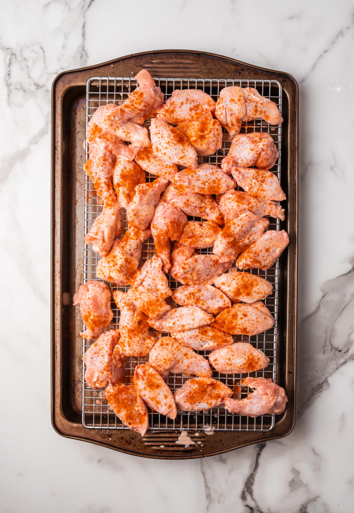 Spices sprinkled over buttermilk brined chicken wings.
