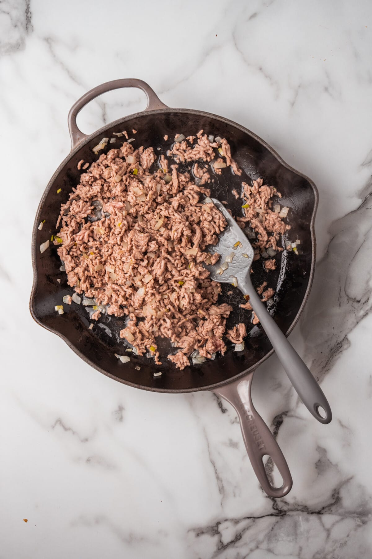 ground pork being browned in skillet.