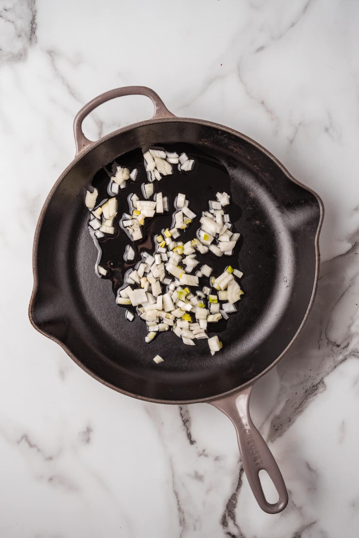 Onions being sauted in skillet.