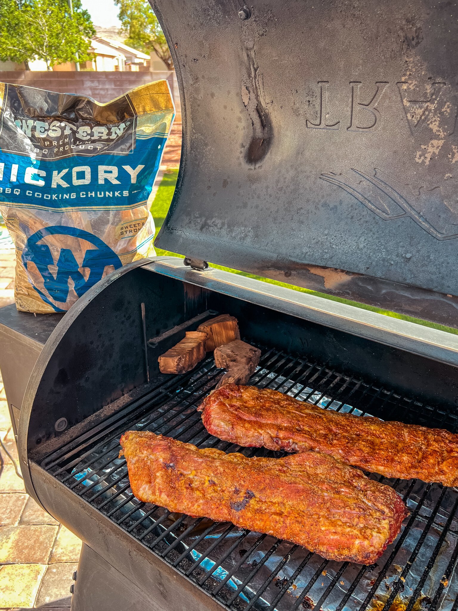 A couple racks of ribs on a pellet grill being smoked.