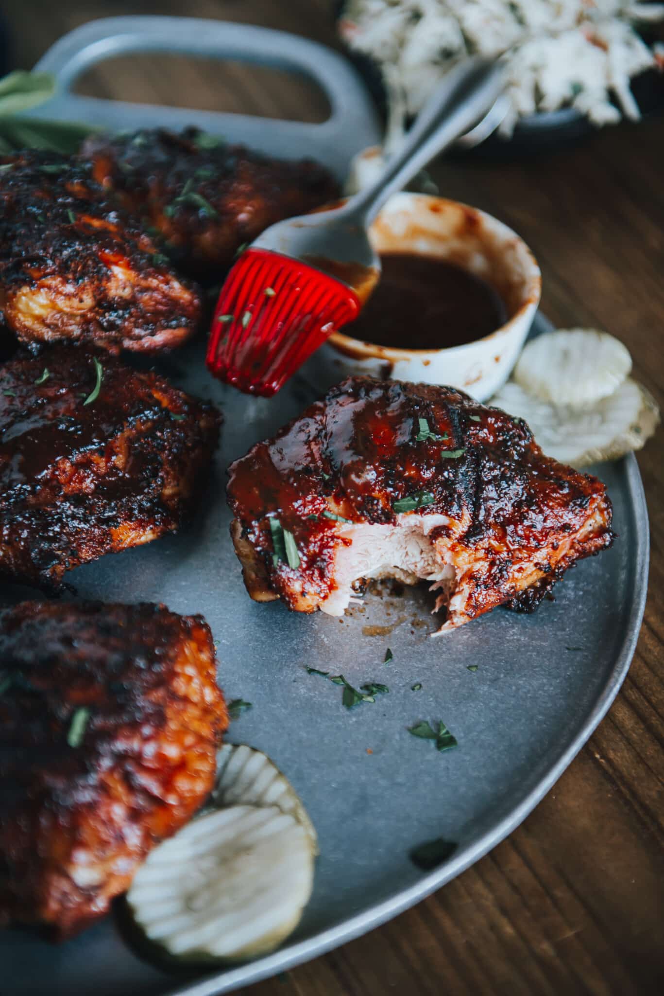 Chicken thigh on platter with bite taken out of it. 