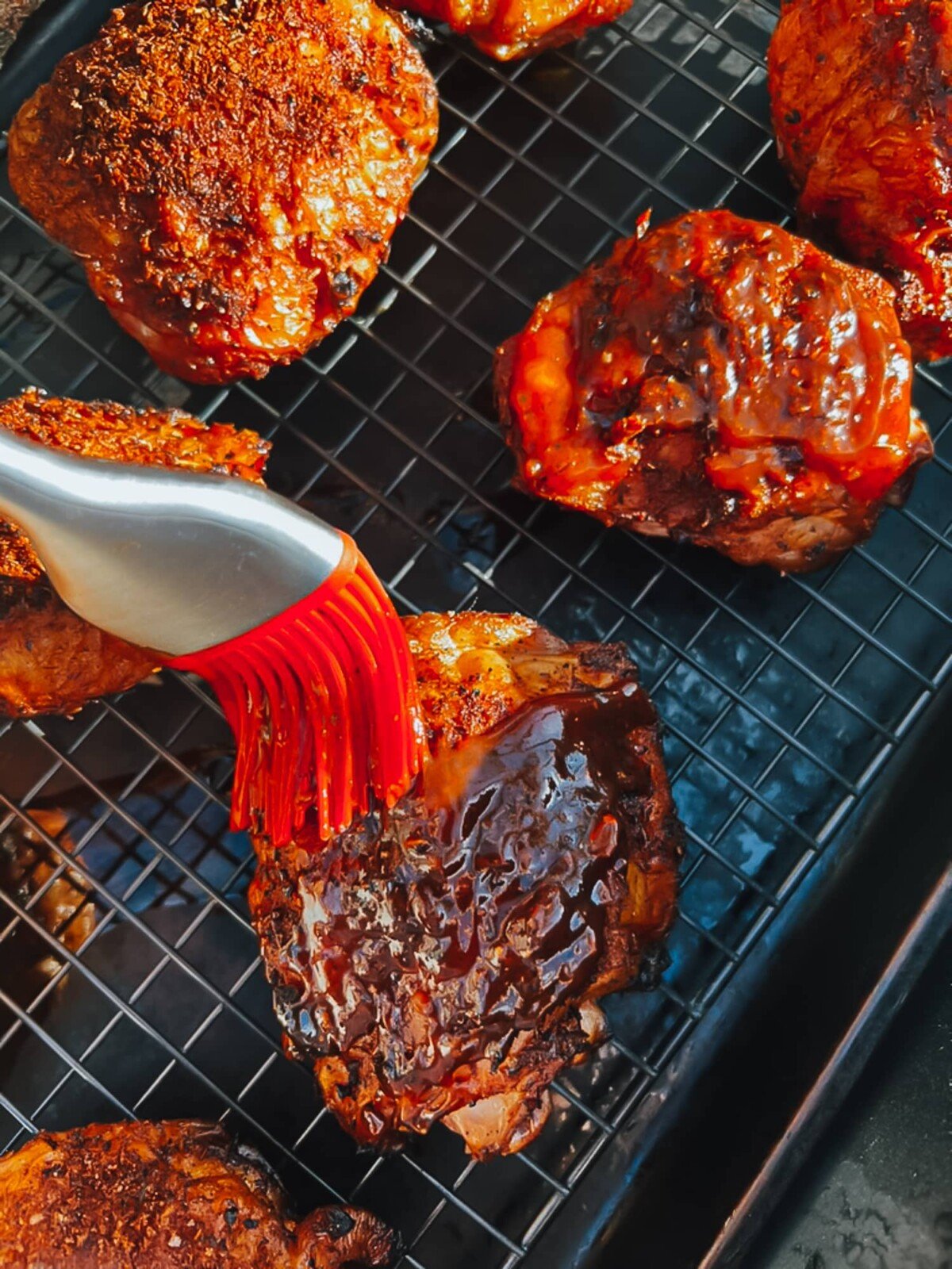 Brushing with barbecue sauce. 