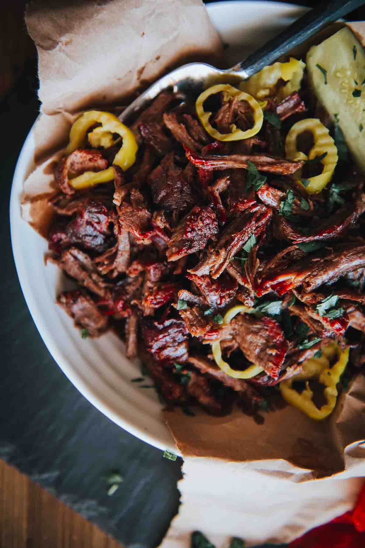 Close up of smoked chuck roast shredded in a bowl for serving. 