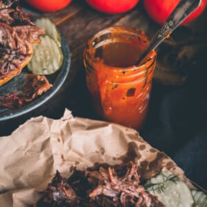 Bbq pulled pork on a plate with Keto BBQ Sauce and pickles.