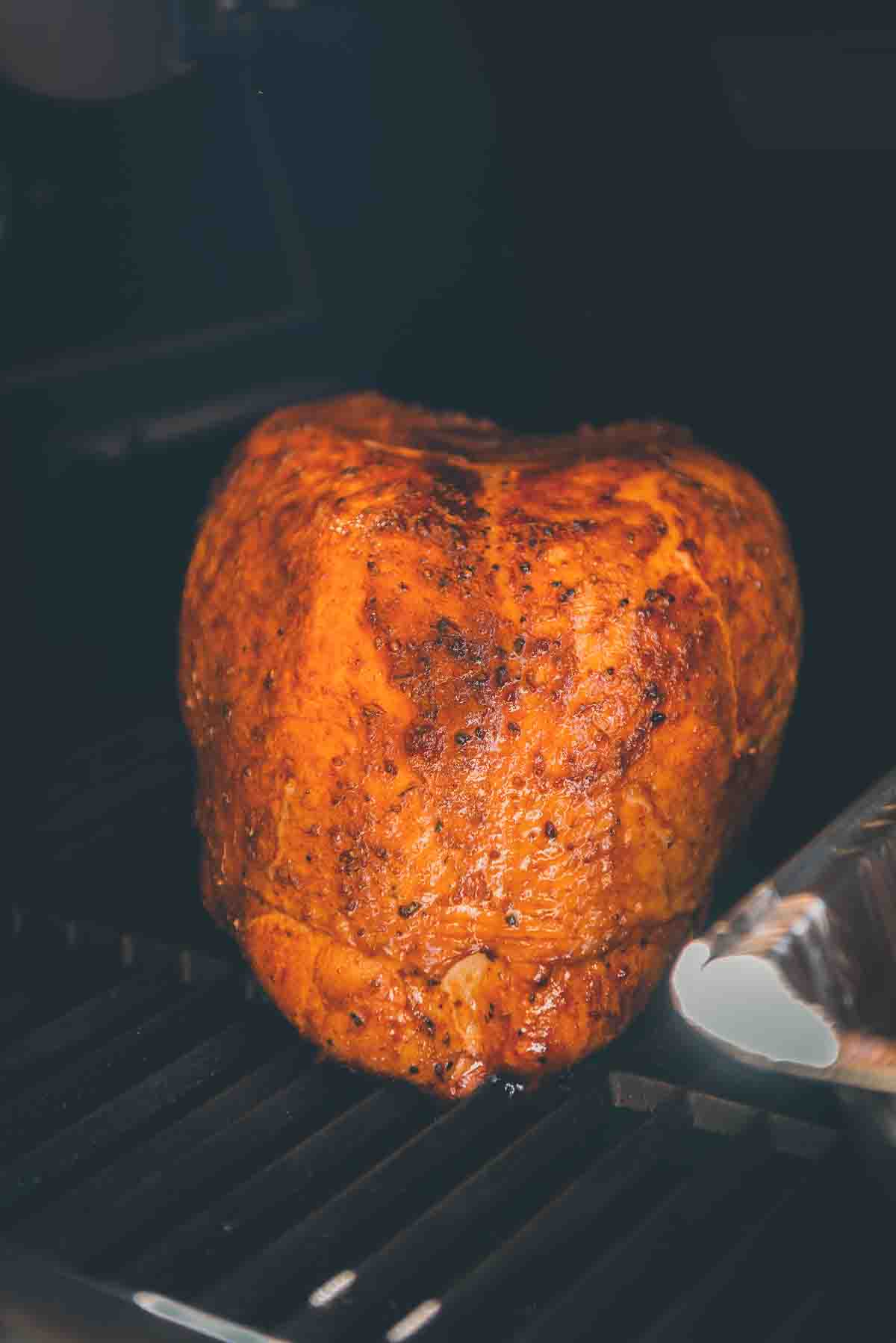 Golden brown skin of the finish smoked turkey on the grill.