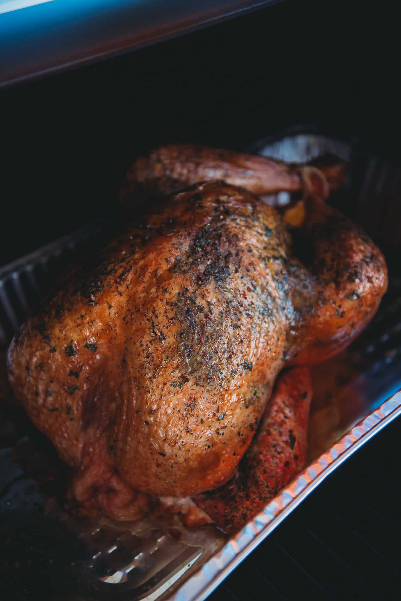 Turkey smoking in a grill, almost to completion showing golden brown skin. 