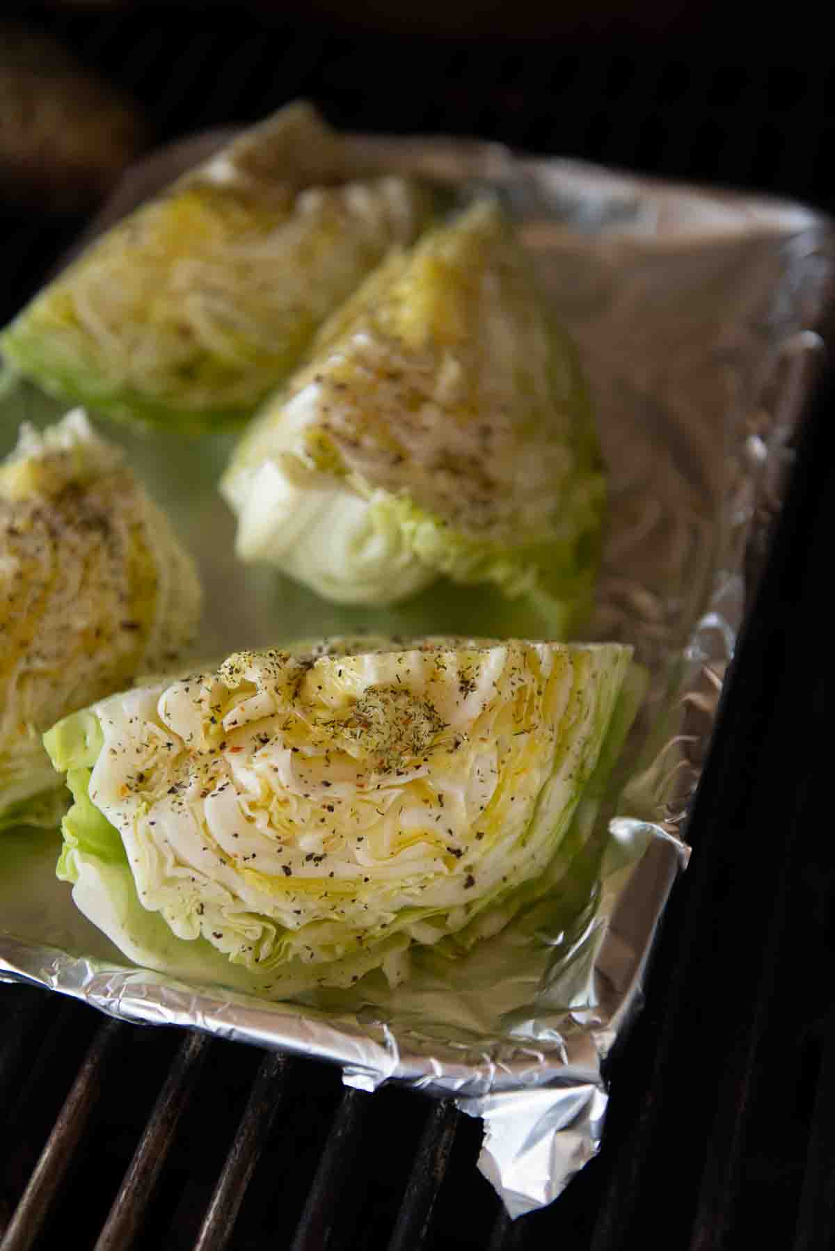 Close up of cabbage wedges on a baking sheet on the grill. 