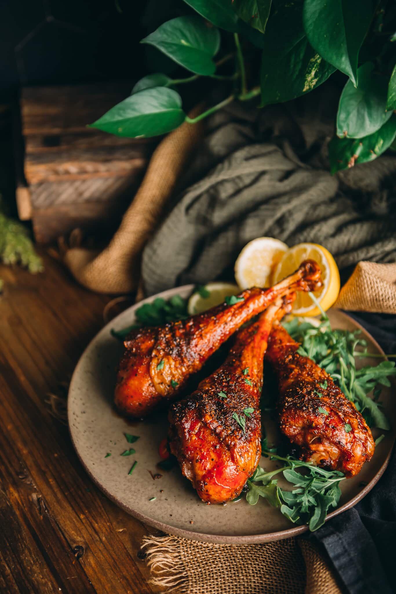 Amber turkey legs arranged on a platter over greens. 