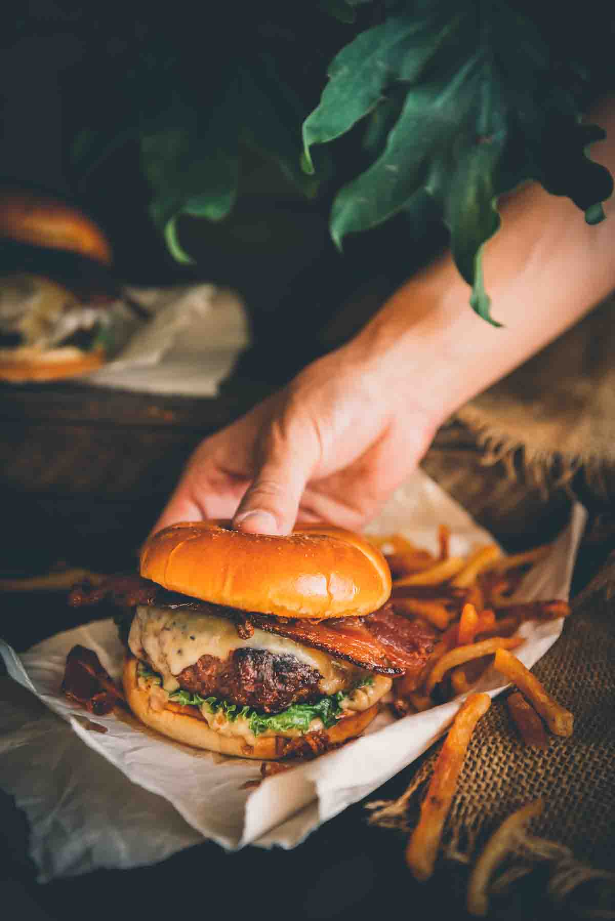 Hand holding venison burger. 