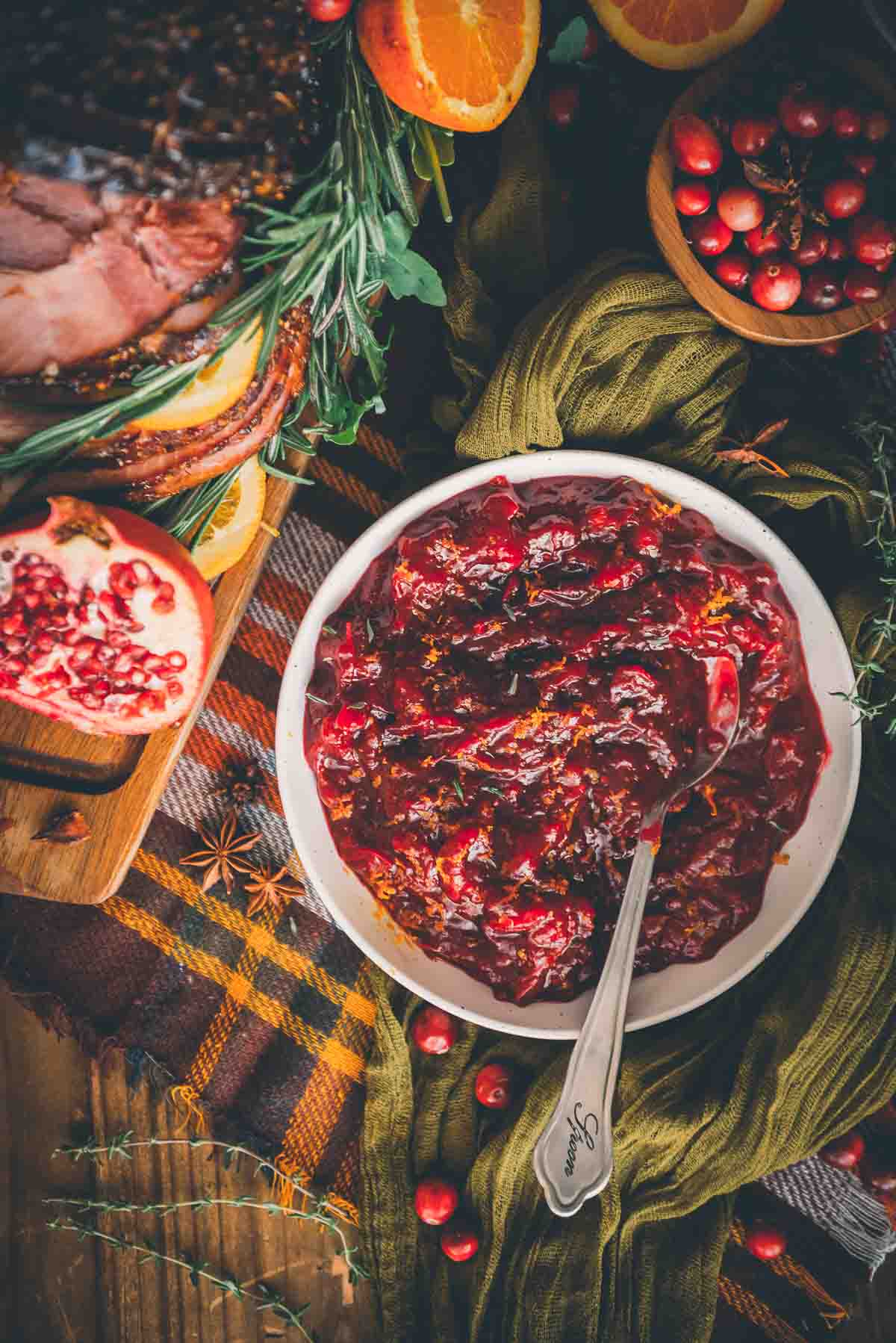 Overhead shot of homemade keto cranberry sauce on a festive table garnished with other seasonal foods. 