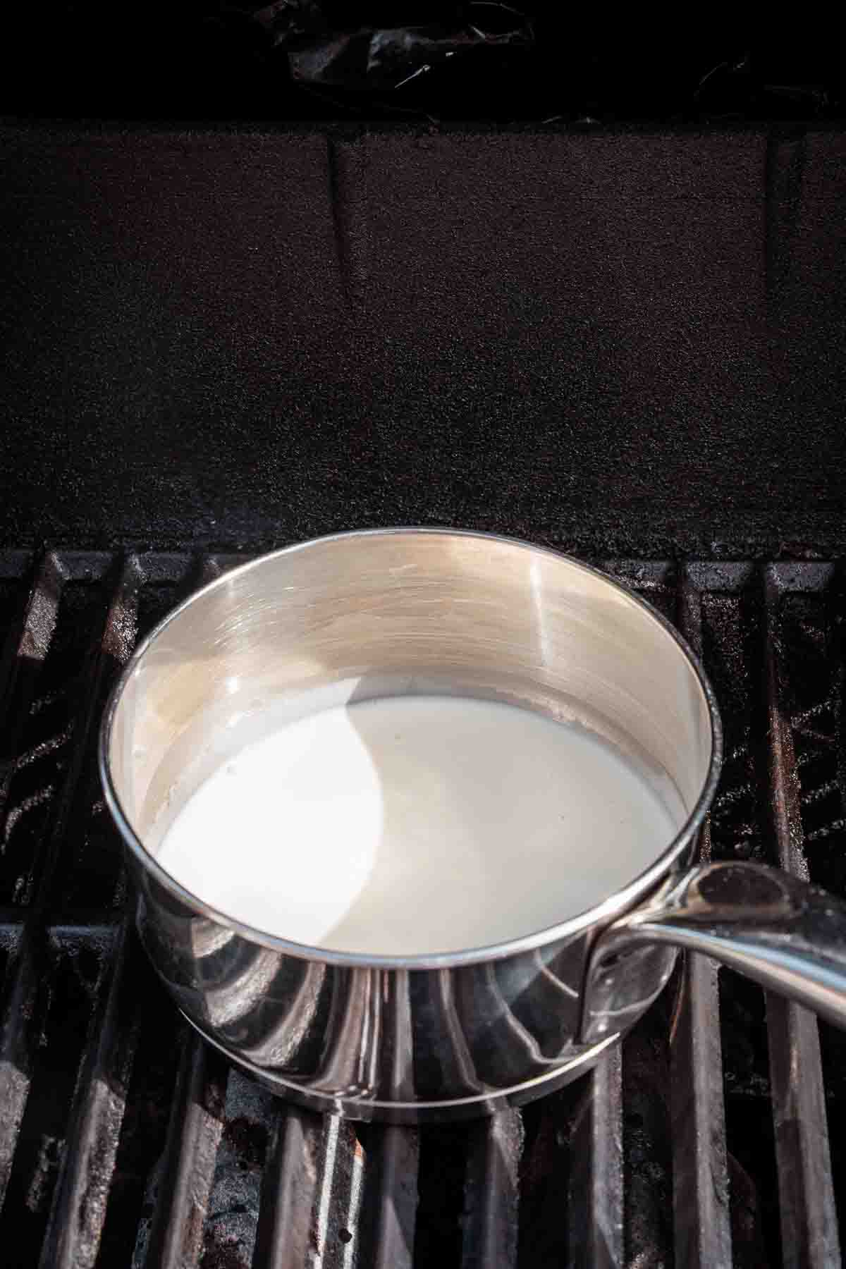 Simmering the cream in a pot on the smoker. 