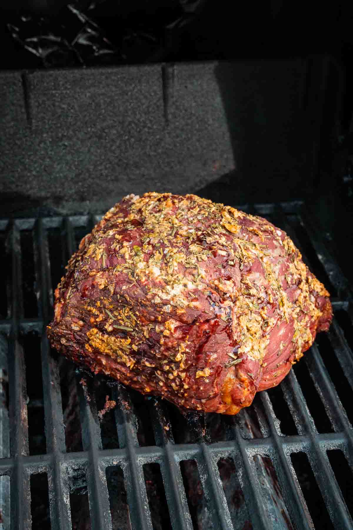 Showing the roast after its been smoked for a while, developing brown  color on exterior.