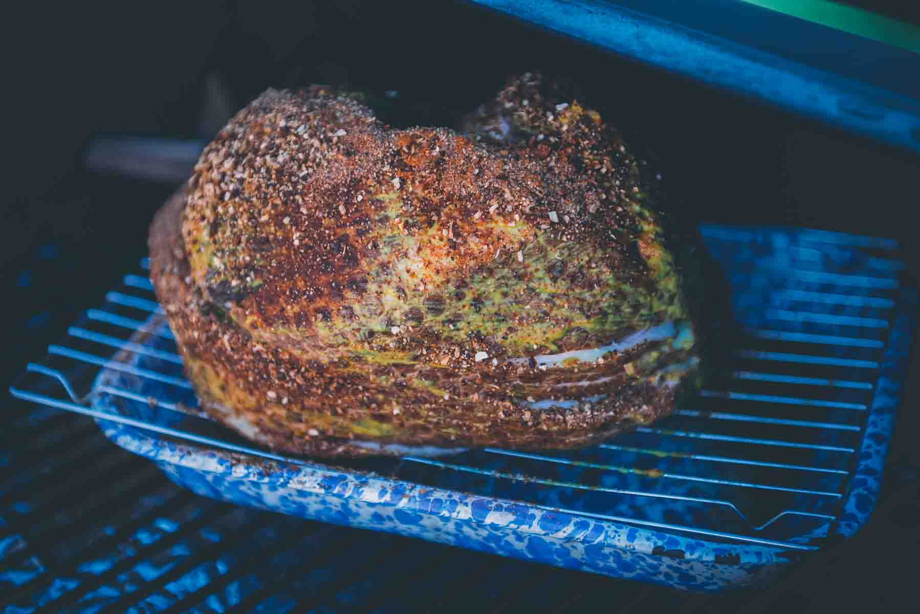 Spiral sliced ham placed on smoker over a pan for drippings.