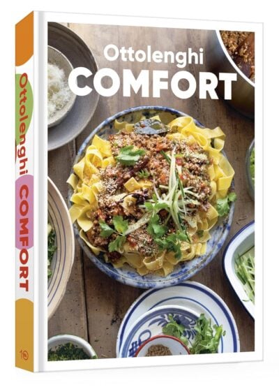 Cover of the cookbook "Ottolenghi Comfort" showcasing a dish of pasta with meat sauce, greens, and herbs, surrounded by ingredients perfect for grilling gifts.