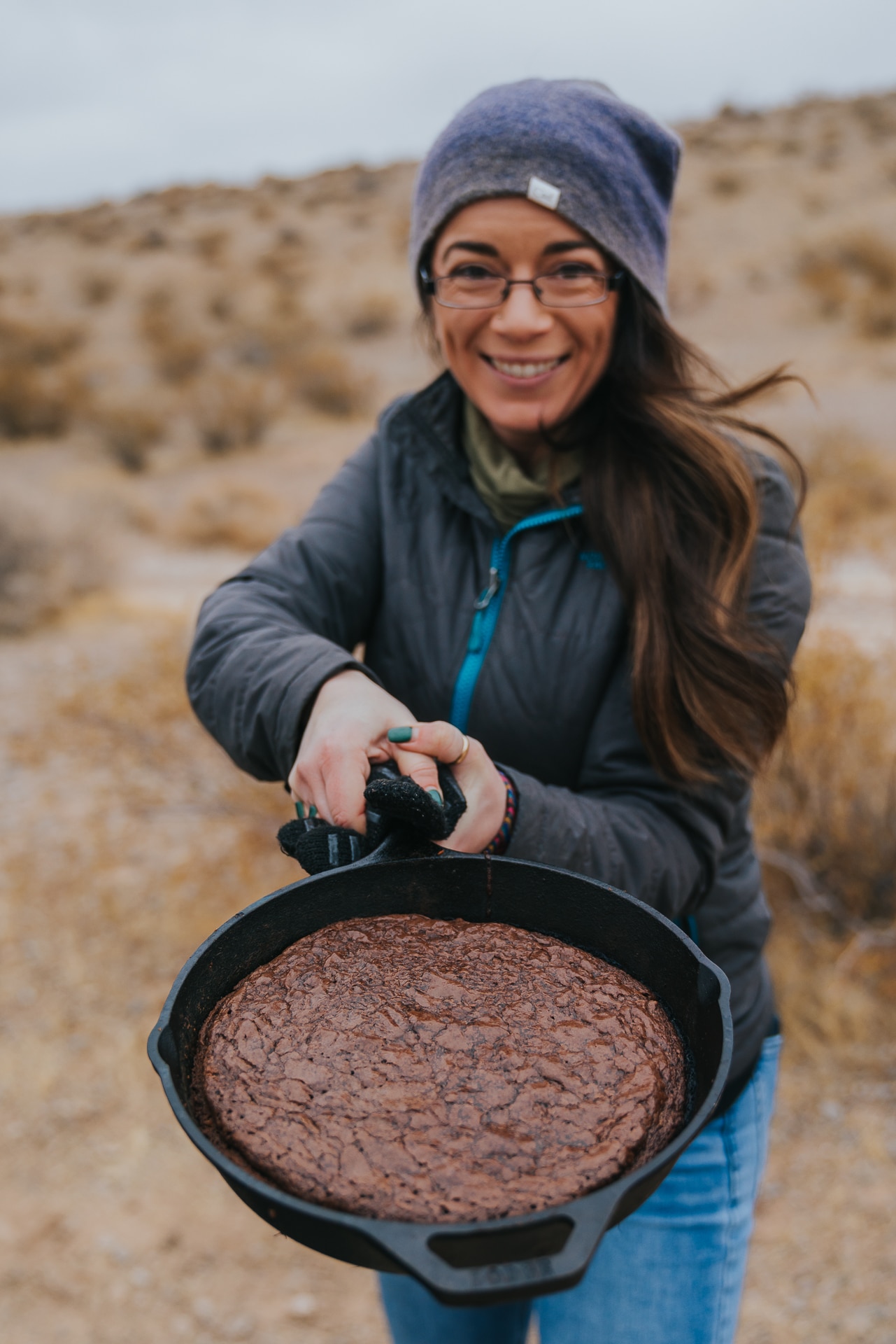 Woman holding a skillet of grilled brownies. 