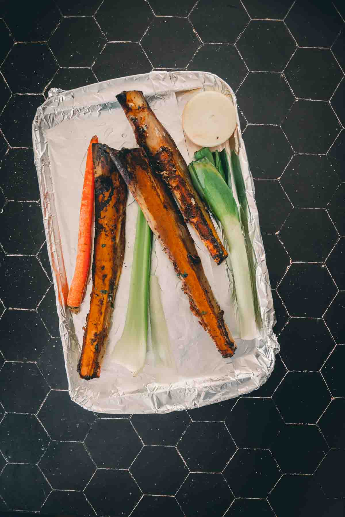 Sheet pan with bones and veggies on it. 