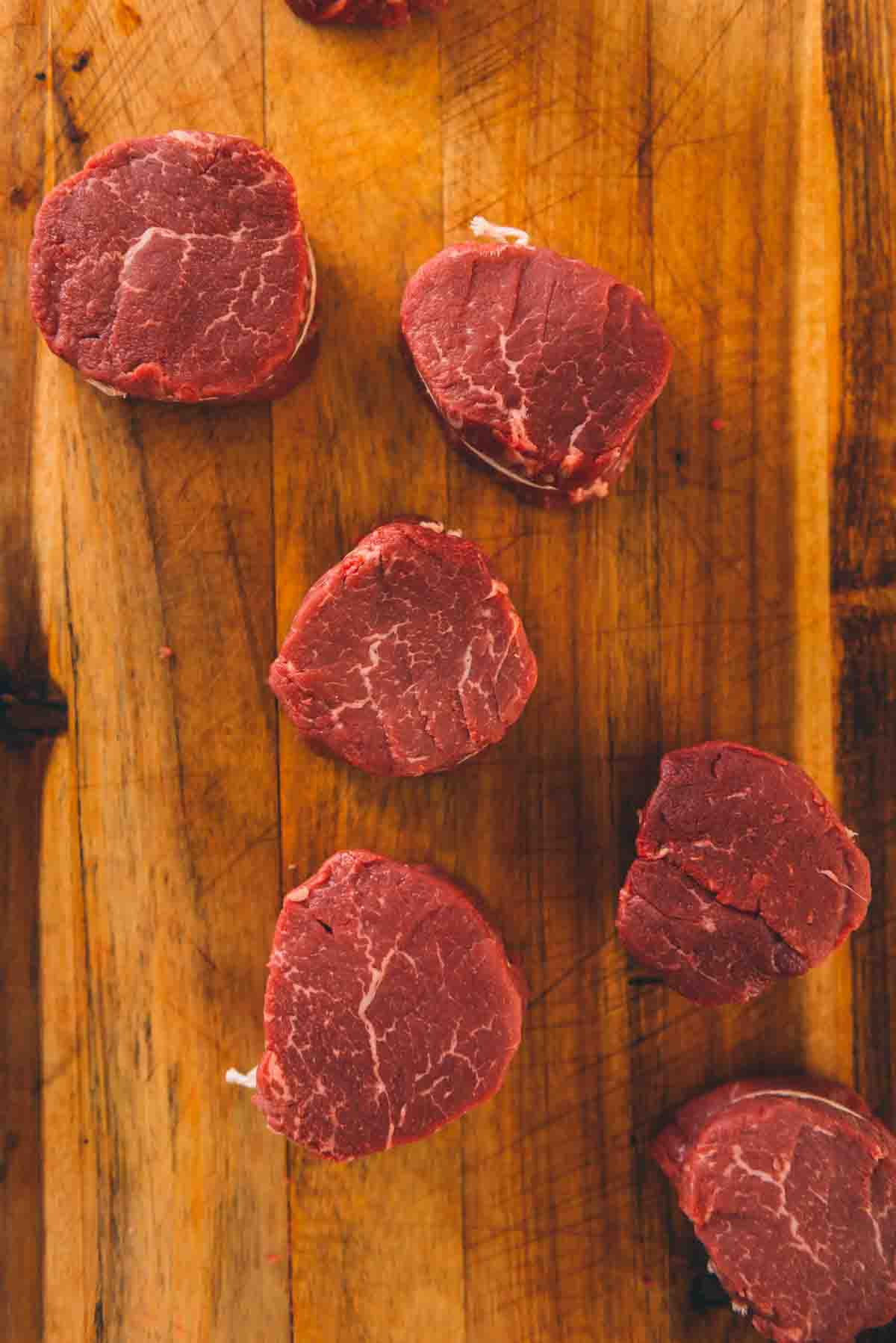 Overhead shot of tenderloin steaks on a cutting board. 