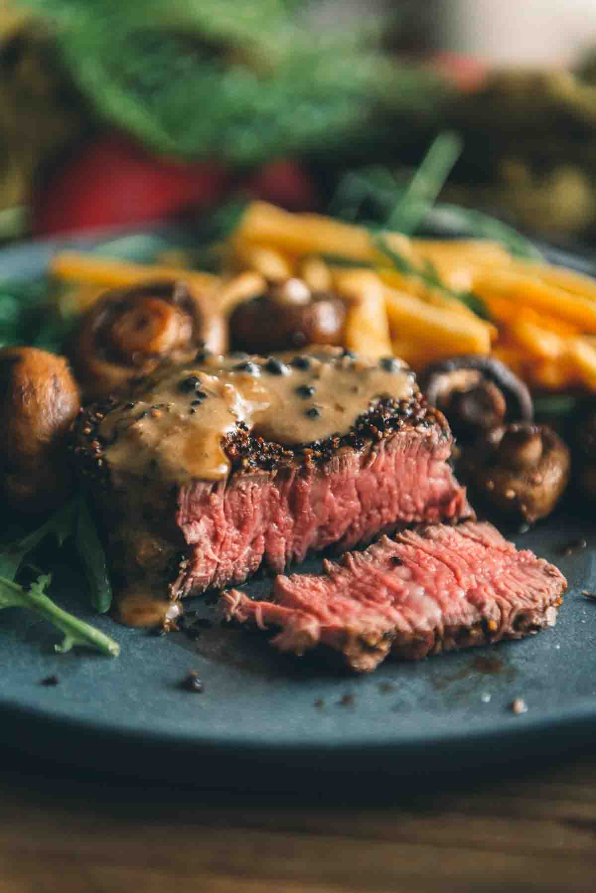 Perfectly cooked and sliced filet mignon steak topped with creamy sauce. 