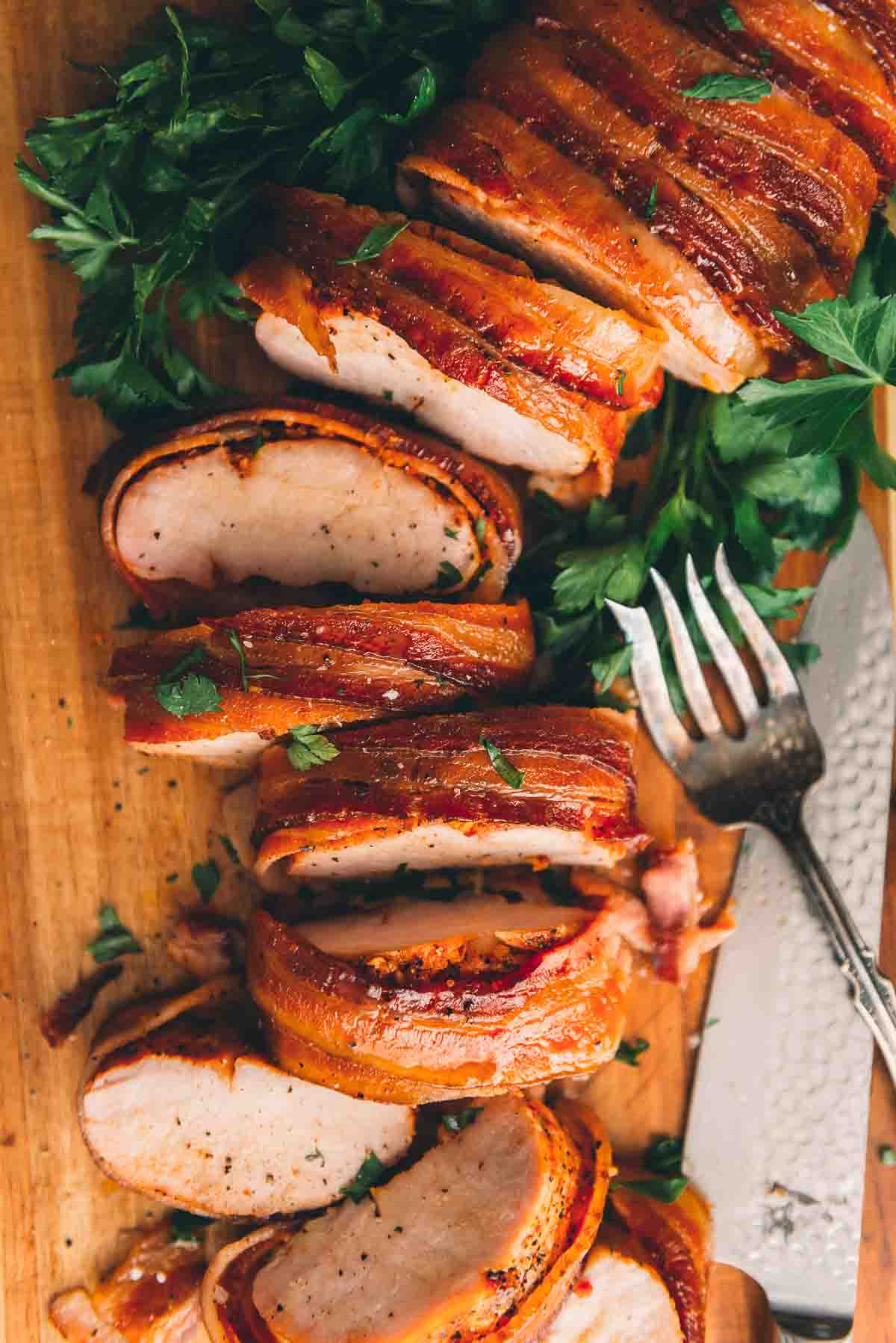 Pork loin sliced for serving on a board. 