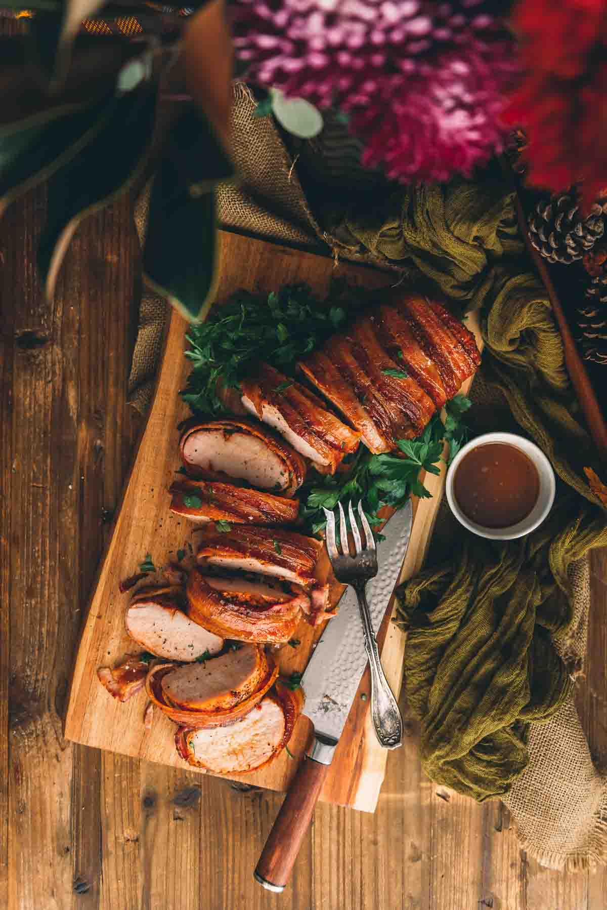 Overhead shot of a smoked pork loin on a cutting board, sliced.
