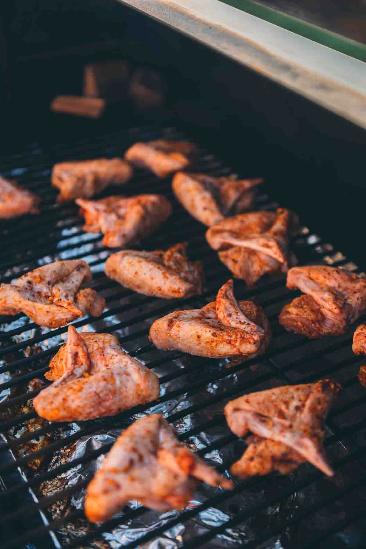 Raw wings placed on a smoker. 