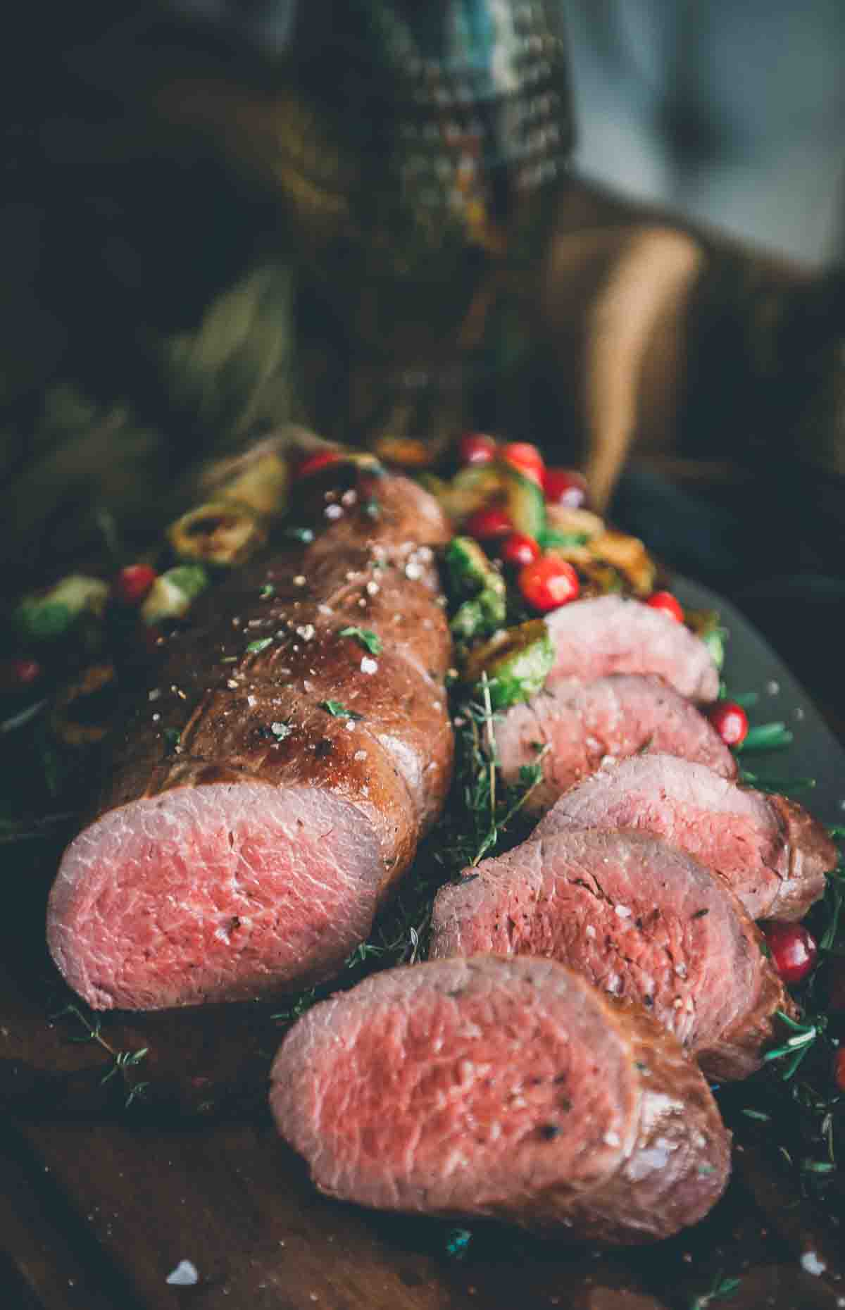Beef tenderloin cooked and sliced, showing a rosy pink center.