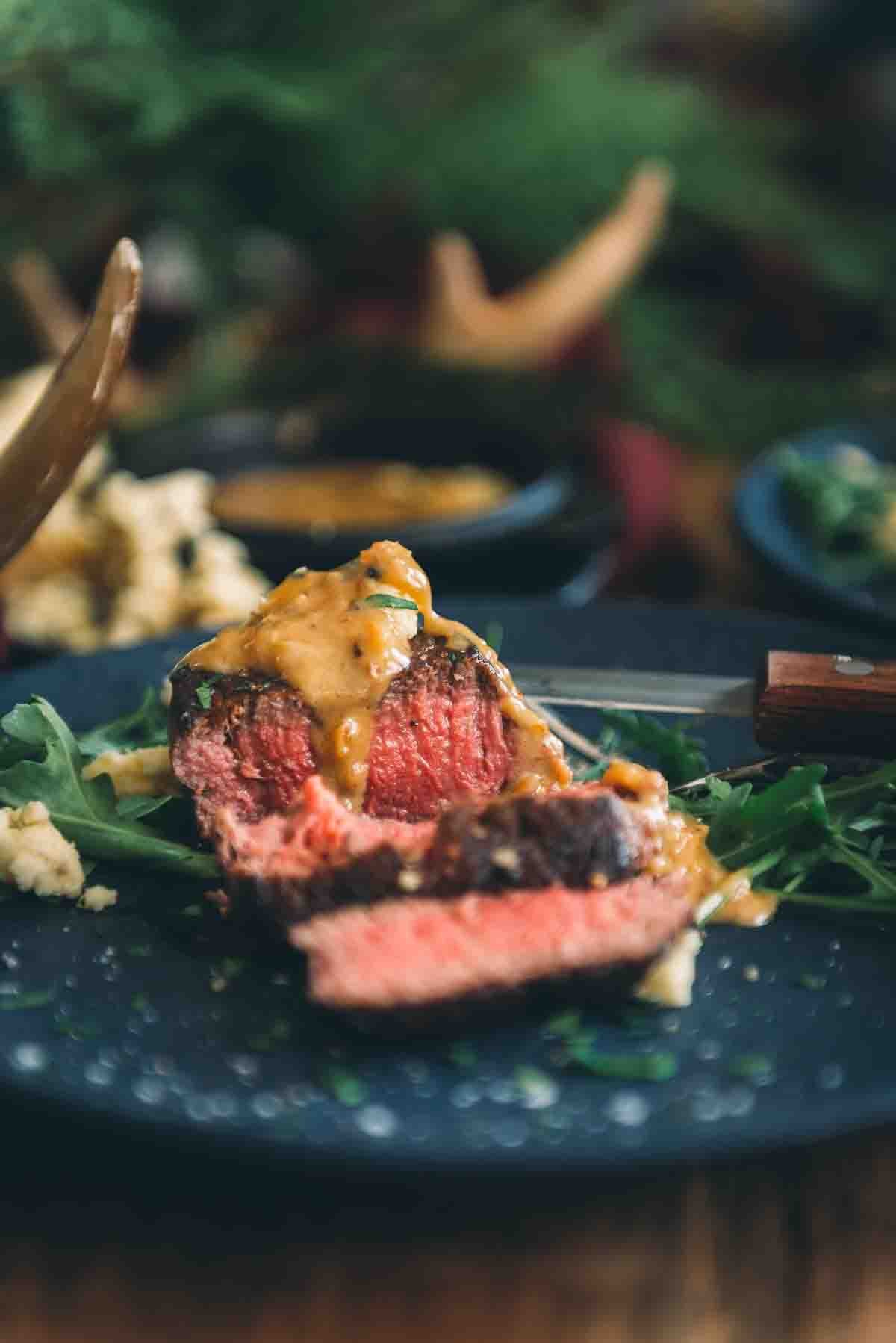 Medium rare filet mignon sliced with a luscious steak sauce spooned over top. 