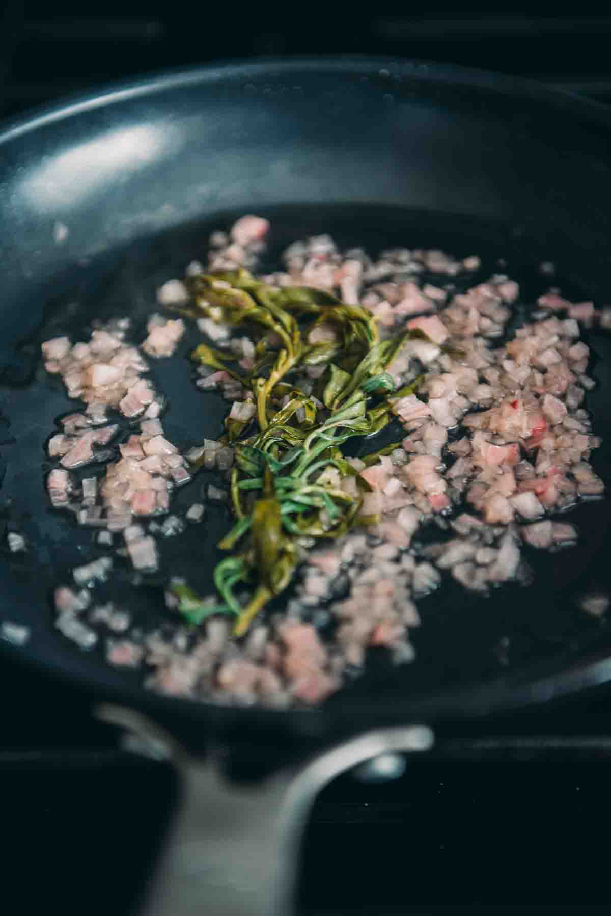 Tarragon cooked down in a pan.