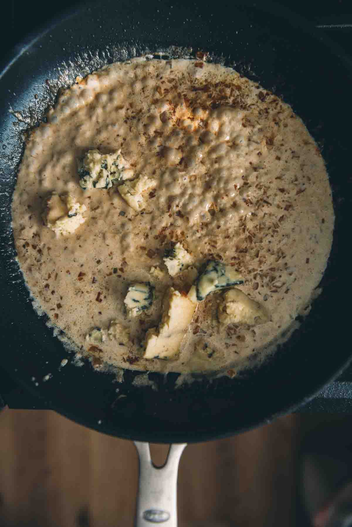 Blue cheese added to the sauce pan.