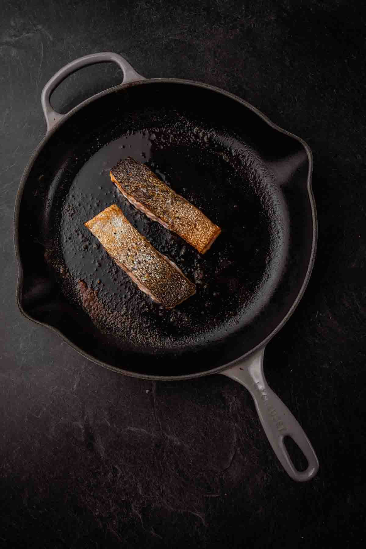 Showing fillets in skillet, crispy skin up and flsh down.