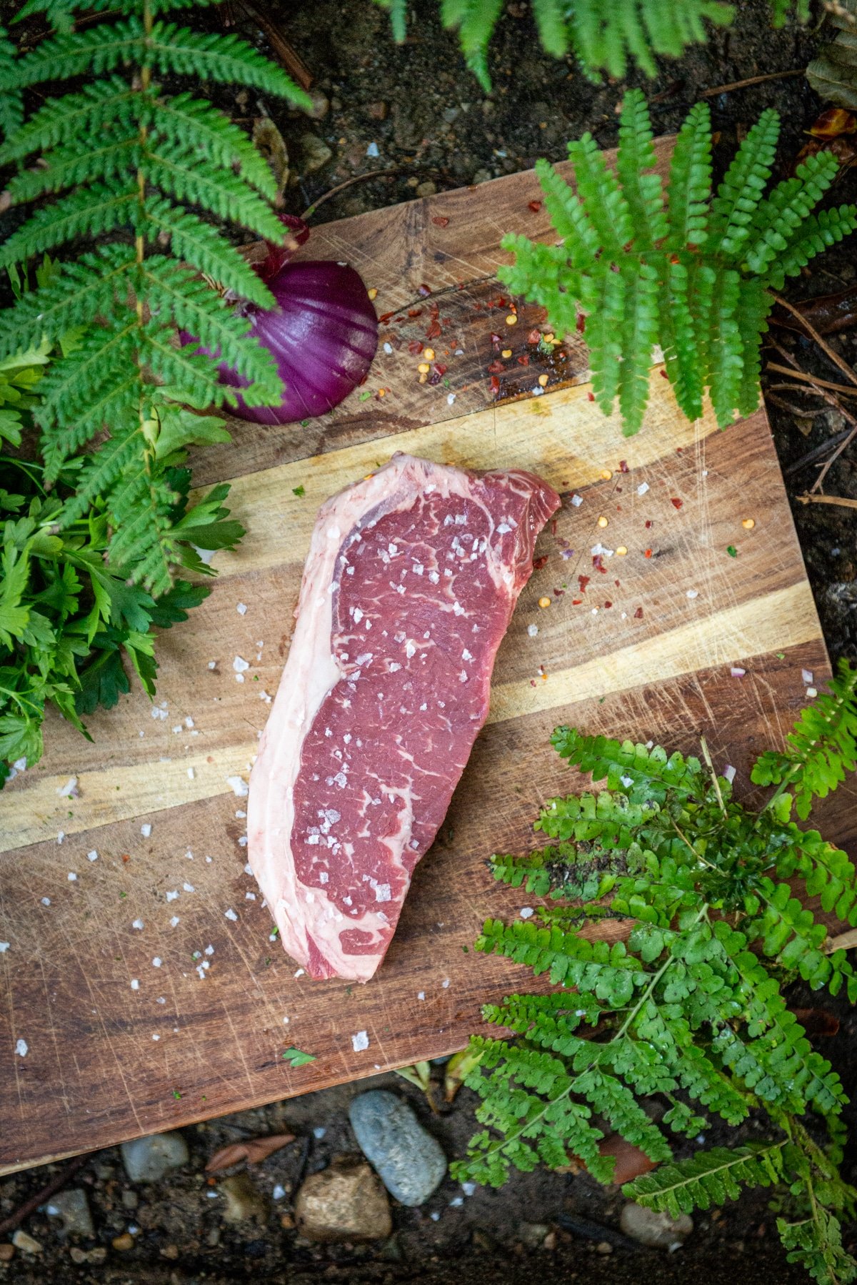 Strip steak on a board seasoned with salt. 