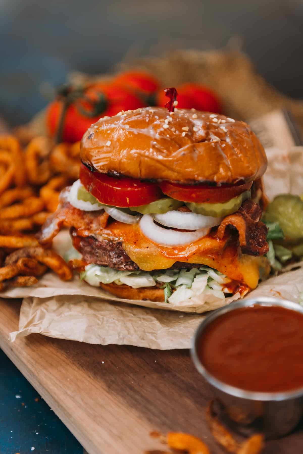 Classic cheeseburger piled with toppings on a platter for eating.