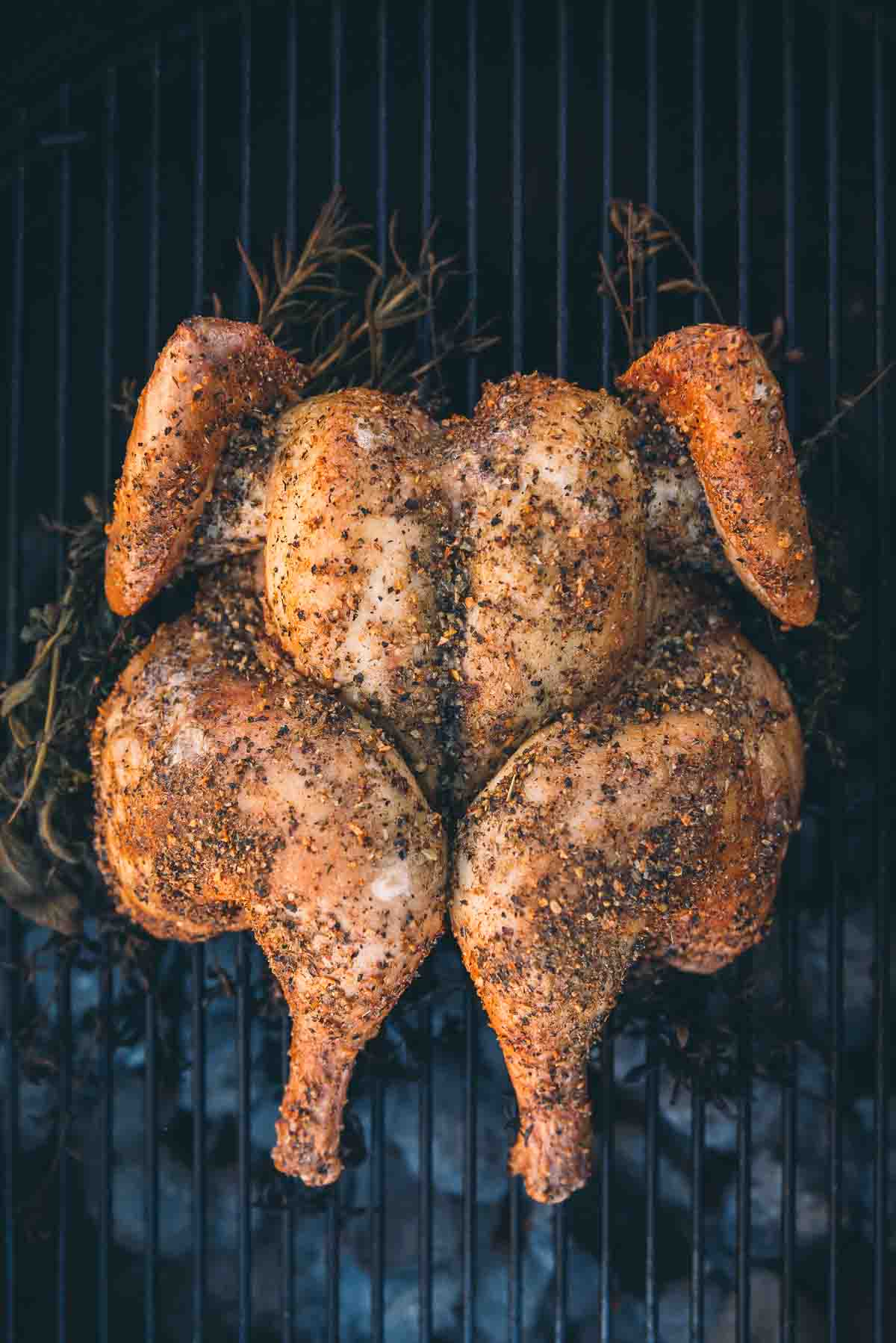 Seasoned chicken, spatchcocked and placed on the grill about halfway through cooking with light golden skin.  