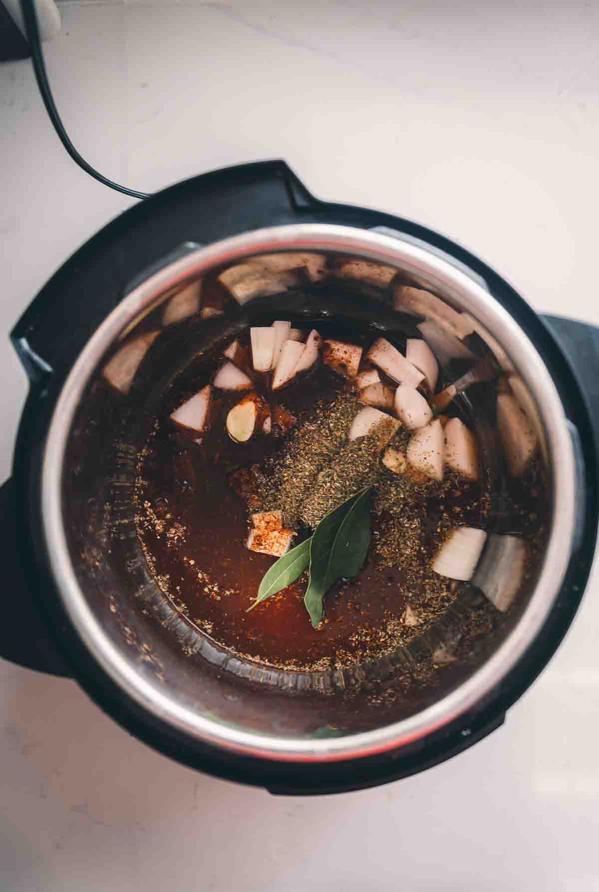 Beef broth and oregano added to the instant pot with other ingredients. 