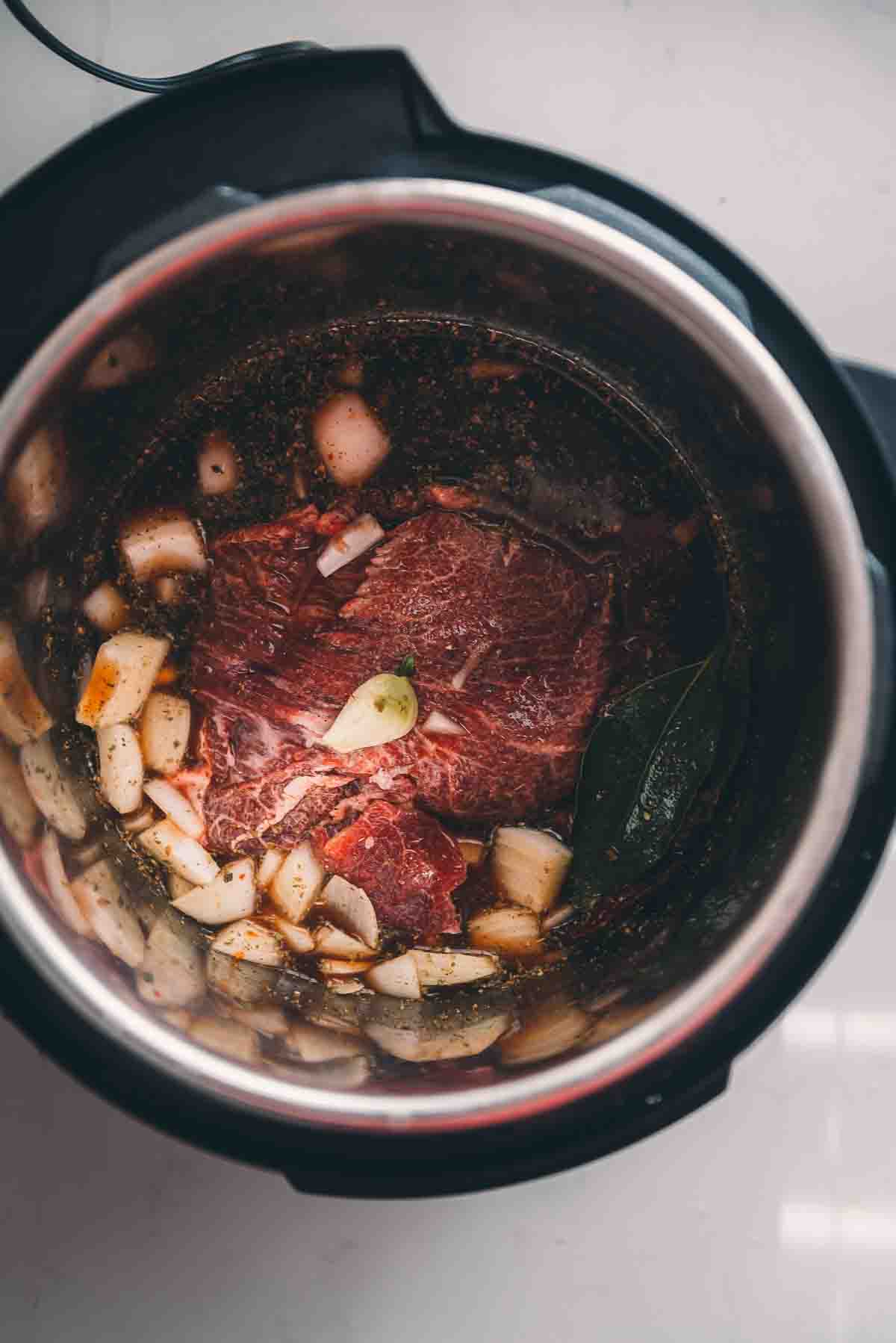 Beef cheek in instant pot with birria ingredients.