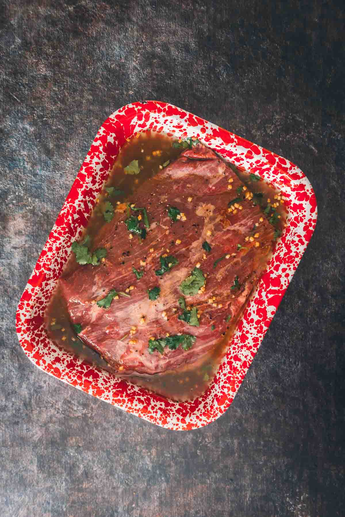 Overhead of flank steak in a pan marinating. 