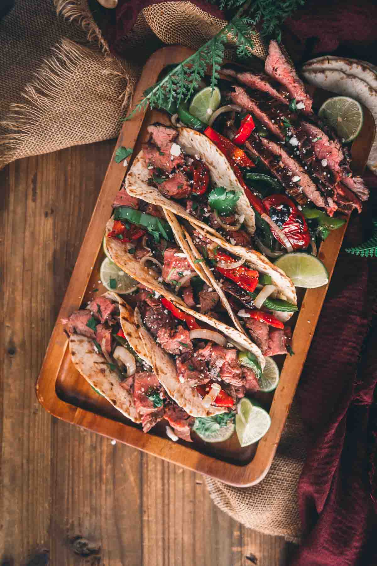 Overhead shot of tacos stuffed with flank steak on a serving plate. 