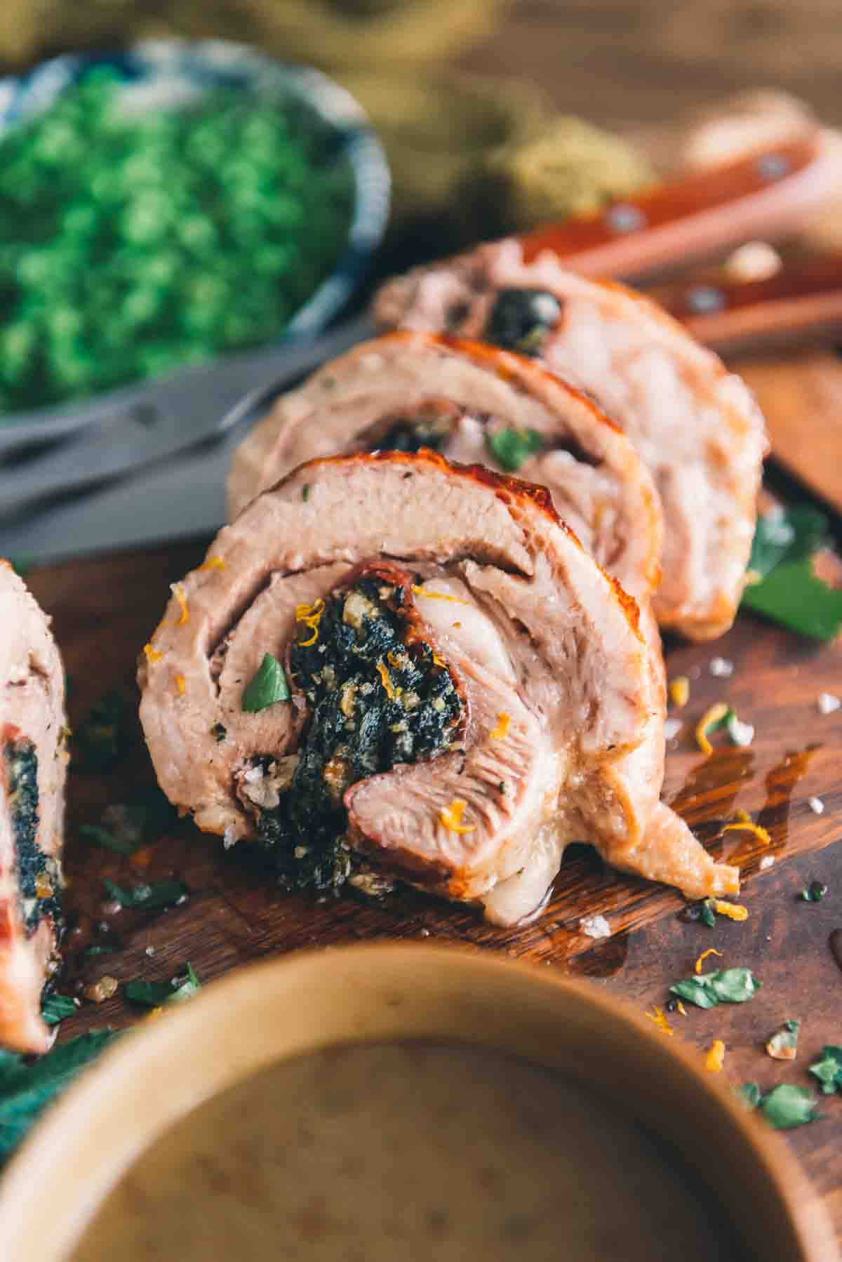 Sliced cooked stuffed veal breast to show spinach filling. 